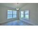 Bright dining room with two large windows and modern chandelier at 1517 Leamington Ln, Winter Haven, FL 33884