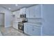 Modern kitchen featuring white cabinets, stainless steel appliances, and stone countertops at 1517 Leamington Ln, Winter Haven, FL 33884