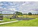 Community playground with swings and slides set against a backdrop of blue skies and scenic views at 1517 Leamington Ln, Winter Haven, FL 33884