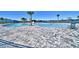 Large community swimming pool surrounded by palm trees and stylish pavers overlooking serene water at 1517 Leamington Ln, Winter Haven, FL 33884
