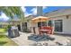 Outdoor patio with a dining set under an umbrella, with a grill and sliding glass doors to the home at 1854 Sherwood Lakes Blvd, Lakeland, FL 33809