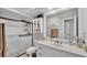 Bright bathroom featuring vanity with sink, shower with glass door, and built-in cabinet above the toilet at 1854 Sherwood Lakes Blvd, Lakeland, FL 33809