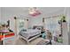 Cozy bedroom features ceiling fan, large window, and a stylish desk area at 1854 Sherwood Lakes Blvd, Lakeland, FL 33809