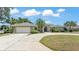Well-manicured home featuring a circular driveway, lush landscaping and attached garage at 1854 Sherwood Lakes Blvd, Lakeland, FL 33809