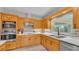 Bright kitchen features oak cabinetry, stainless steel appliances, and stylish backsplash at 1854 Sherwood Lakes Blvd, Lakeland, FL 33809