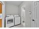 Convenient laundry room featuring modern washer and dryer with a doorway to a bathroom at 1854 Sherwood Lakes Blvd, Lakeland, FL 33809