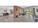 Open living room featuring a brick fireplace, wood floors, and sliding glass doors to the outdoor view at 1854 Sherwood Lakes Blvd, Lakeland, FL 33809