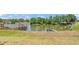 Scenic view of the pond showcasing a gazebo and dock, with lush green trees surrounding the property at 1854 Sherwood Lakes Blvd, Lakeland, FL 33809