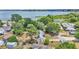 A high angle view of a home, surrounded by trees, featuring a lake in the background at 1965 Avenue F Sw, Winter Haven, FL 33880
