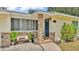 Close-up of a welcoming front porch with stone accents, a cozy bench, and a neatly landscaped entrance at 1965 Avenue F Sw, Winter Haven, FL 33880