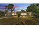 Inviting single-story home featuring a well-maintained lawn, a charming front porch, and a cozy porch swing at 1965 Avenue F Sw, Winter Haven, FL 33880