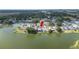 An aerial view of a home with a screened in back porch by the lake, surrounded by mature trees at 2015 Hatteras Pt, Lakeland, FL 33813