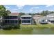 The home's backyard features a screened-in porch overlooking a lush green lawn and a serene lake at 2015 Hatteras Pt, Lakeland, FL 33813
