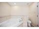 Bathroom featuring a soaking tub with tiled surround and a modern toilet at 2015 Hatteras Pt, Lakeland, FL 33813
