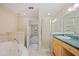 Well-lit bathroom with a glass-enclosed shower, vanity with green countertops, and soaking tub at 2015 Hatteras Pt, Lakeland, FL 33813