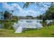 Scenic lake view featuring a private dock and lush green surroundings on a sunny day at 2015 Hatteras Pt, Lakeland, FL 33813
