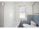 Bathroom showcasing a shower-tub combo and a toilet with tile backsplash at 202 W Hancock St, Lakeland, FL 33803
