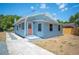 This single-story home has an entryway on the side with a pink door and a tidy yard at 202 W Hancock St, Lakeland, FL 33803