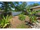 Lush backyard featuring a well-maintained garden bed with tropical plants and rocks at 2103 Sylvester Ct, Lakeland, FL 33803