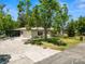 Single-story home with an attached garage, screened-in porch, and mature trees at 2103 Sylvester Ct, Lakeland, FL 33803