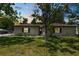 Charming single-story home with a well-maintained lawn and mature trees in a serene neighborhood at dusk at 2103 Sylvester Ct, Lakeland, FL 33803