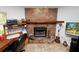 Close up of a brick fireplace with a wooden mantel and office area at 2103 Sylvester Ct, Lakeland, FL 33803