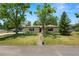 Well-maintained front yard with mature trees enhancing the curb appeal of this charming single-story home at 2103 Sylvester Ct, Lakeland, FL 33803