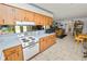Functional kitchen with wooden cabinets, an electric stovetop, and an open view into the living area at 2103 Sylvester Ct, Lakeland, FL 33803