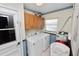 Laundry room features appliances, cabinets, tiled floor and a utility sink with access to the outside at 2103 Sylvester Ct, Lakeland, FL 33803