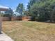 Backyard with a large grassy area, a sturdy wooden fence and partial shade at 2213 Eastmeadows Rd, Lakeland, FL 33812