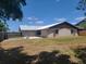 Backyard with a large grassy area and a sturdy wooden fence at 2213 Eastmeadows Rd, Lakeland, FL 33812