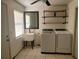 Well-equipped laundry room featuring a sink, modern washer and dryer, and shelving for organization at 2213 Eastmeadows Rd, Lakeland, FL 33812