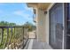 The condo's balcony offers metal railings, a sliding glass door, and views of trees at 235 6Th Nw St # 307, Winter Haven, FL 33881