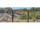 View from the balcony with decorative metal railings, overlooking parking and mature landscaping at 235 6Th Nw St # 307, Winter Haven, FL 33881