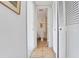 Hallway view of a bathroom with tiled floor and walls, featuring white fixtures at 235 6Th Nw St # 307, Winter Haven, FL 33881