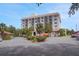 Multi-story building surrounded by greenery, palm trees, and construction equipment for maintenance and updates at 235 6Th Nw St # 307, Winter Haven, FL 33881