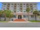 Stunning exterior shot showcasing a multi-story residential building with private balconies and lush palm trees at 235 6Th Nw St # 307, Winter Haven, FL 33881