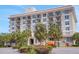 Multi-story residential building with balconies, surrounded by palm trees, and featuring modern equipment for maintenance at 235 6Th Nw St # 307, Winter Haven, FL 33881