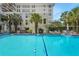 Sparkling community pool with poolside seating, set against the backdrop of the multi-story residential building at 235 6Th Nw St # 307, Winter Haven, FL 33881
