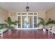 Elegant entrance with double doors, tiled flooring, and lush potted plants at 235 6Th Nw St # 307, Winter Haven, FL 33881