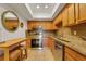 This kitchen features wooden cabinets, granite countertops, stainless steel appliances, and a kitchen island with seating at 235 6Th Nw St # 307, Winter Haven, FL 33881