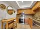 This kitchen features wooden cabinets, granite countertops, stainless steel appliances, and a kitchen island with seating at 235 6Th Nw St # 307, Winter Haven, FL 33881