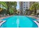 A serene pool area surrounded by lush greenery and foliage, with lounge chairs available for relaxation at 235 6Th Nw St # 307, Winter Haven, FL 33881