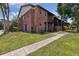 Image displays brick condo with a balcony, sidewalk, lush landscaping, and trees at 2369 Tom Jones St # 8, Orlando, FL 32839