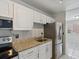 Kitchen features white cabinets, stainless steel appliances, a granite countertop, and a tile backsplash at 2369 Tom Jones St # 8, Orlando, FL 32839