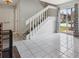 Open-concept living space with tile flooring, white staircase, and a sliding glass door at 2369 Tom Jones St # 8, Orlando, FL 32839