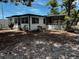 This is a single story home with a screened in porch and an overgrown yard at 2610 Eaton Ave, Lakeland, FL 33803