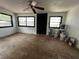 Spacious living room with natural light, ceiling fan, and original wood flooring, ready for renovation at 2610 Eaton Ave, Lakeland, FL 33803