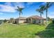 Stunning single-story home featuring a lush green lawn and elegant palm trees at 2743 Verandah Vue Way, Lakeland, FL 33812