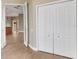 Hallway with wood-look tile floors, closet and an opening to the kitchen and living spaces at 2743 Verandah Vue Way, Lakeland, FL 33812
